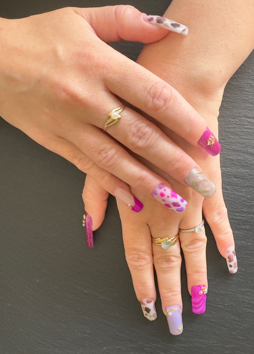 Ongles rose fluo avec fleurs sur mains croisées