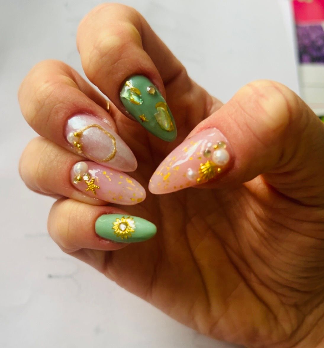 Ongles verts avec fleurs et détails dorés
